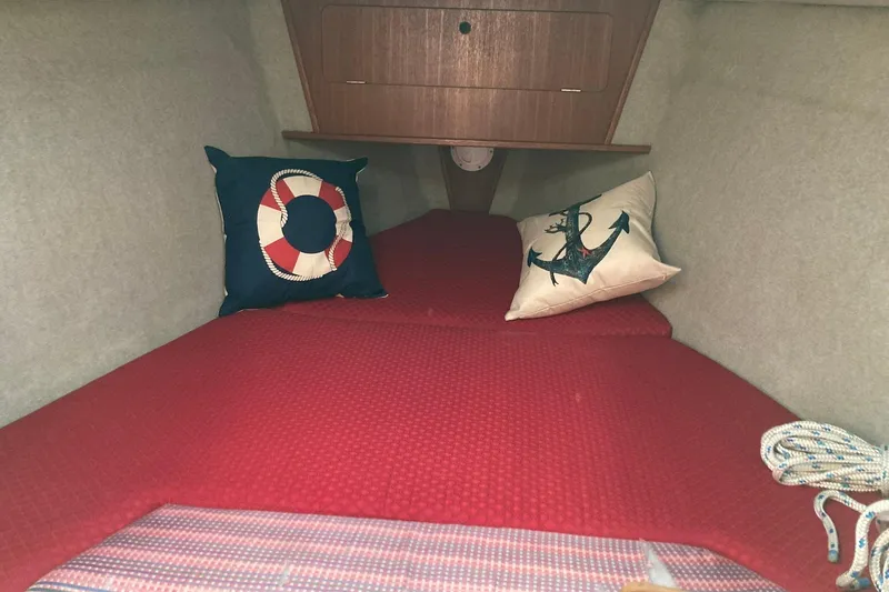 Slide: The Image of Cozy cabin interior of 1987 Hunter Legend 35 sailboat with nautical-themed pillows. - 18