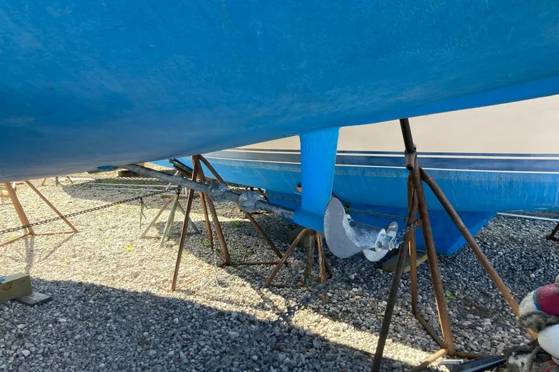 Slide: The Image of 1987 Hunter Legend 35 sailboat on stands, showing blue hull and anchor. - 2
