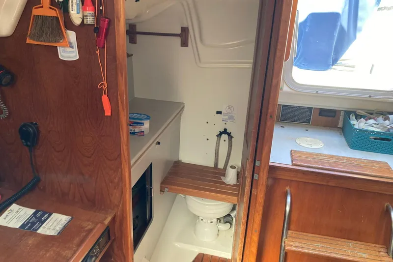 Slide: The Image of Interior of 1987 Hunter Legend 35 sailboat showing compact bathroom and wooden cabinetry. - 22