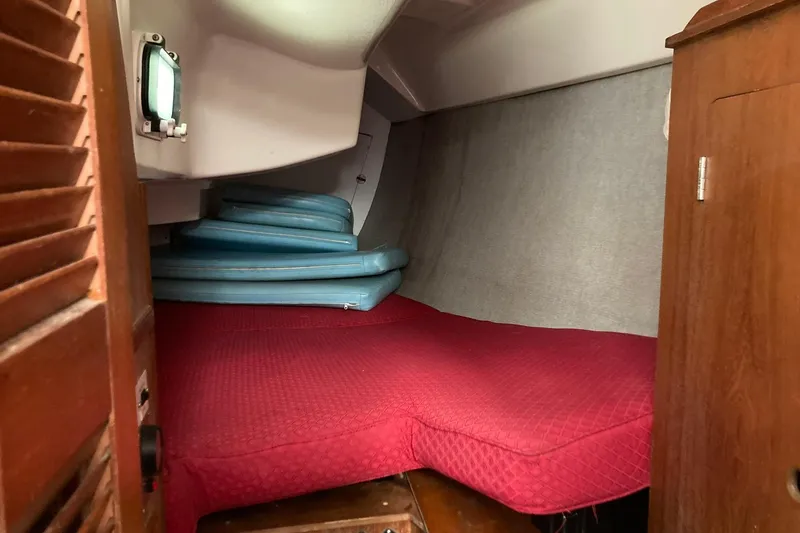 Slide: The Image of Cozy cabin interior of 1987 Hunter Legend 35 sailboat with red bedding. - 23