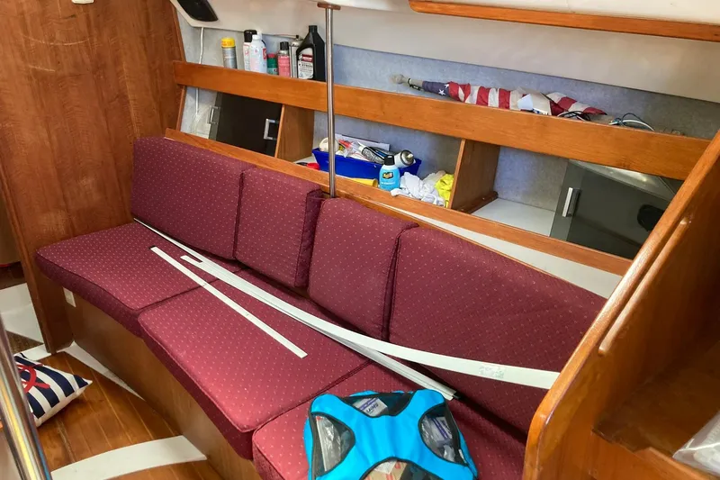 Slide: The Image of Interior of 1987 Hunter Legend 35 sailboat with maroon cushions and storage shelves. - 36