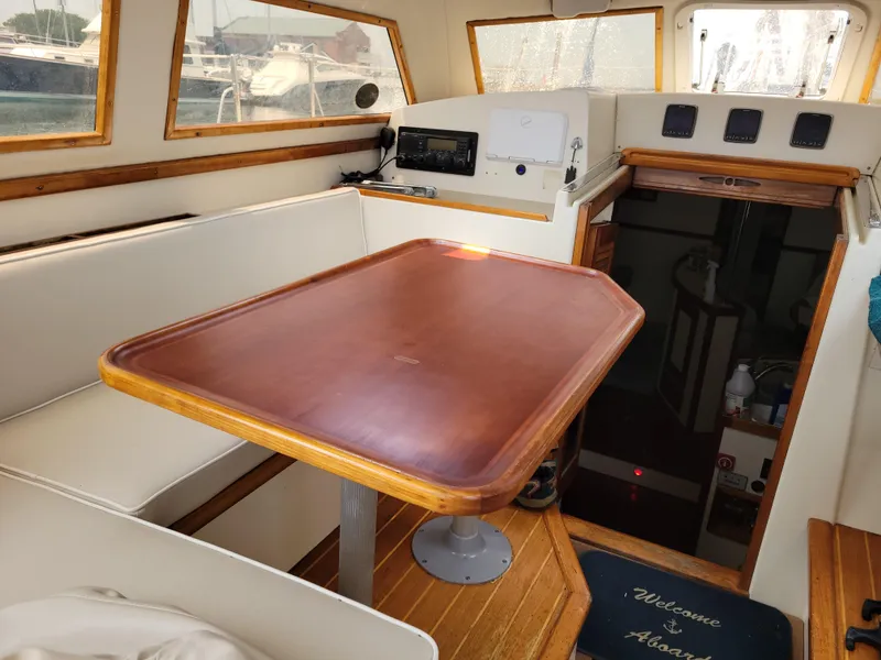 Slide: The Image of Interior of 1996 Little Harbor 51 Pilothouse with wooden table and seating area. - 18