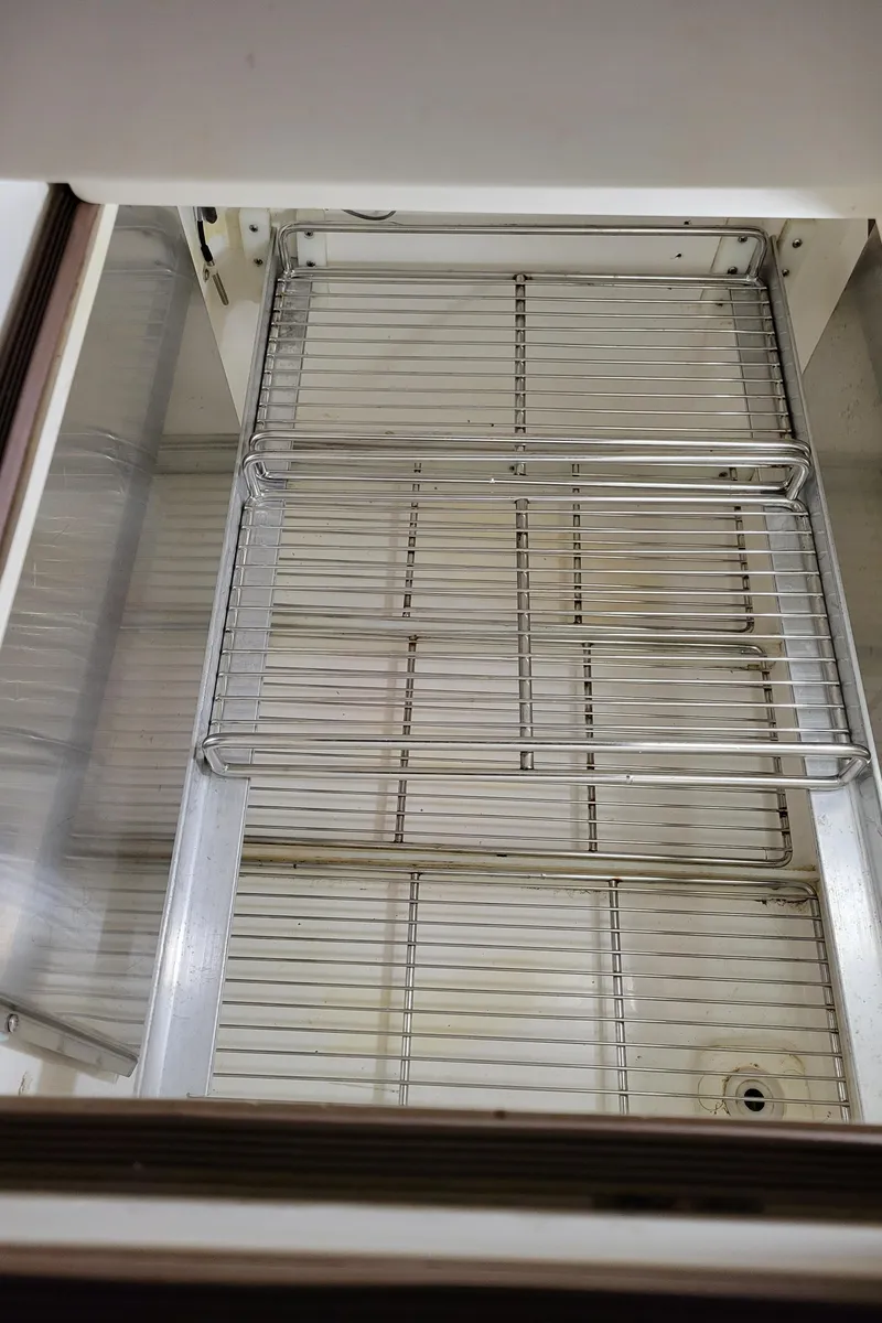 Slide: The Image of Empty refrigerator interior with wire shelves in a 1996 Little Harbor 51 Pilothouse. - 30