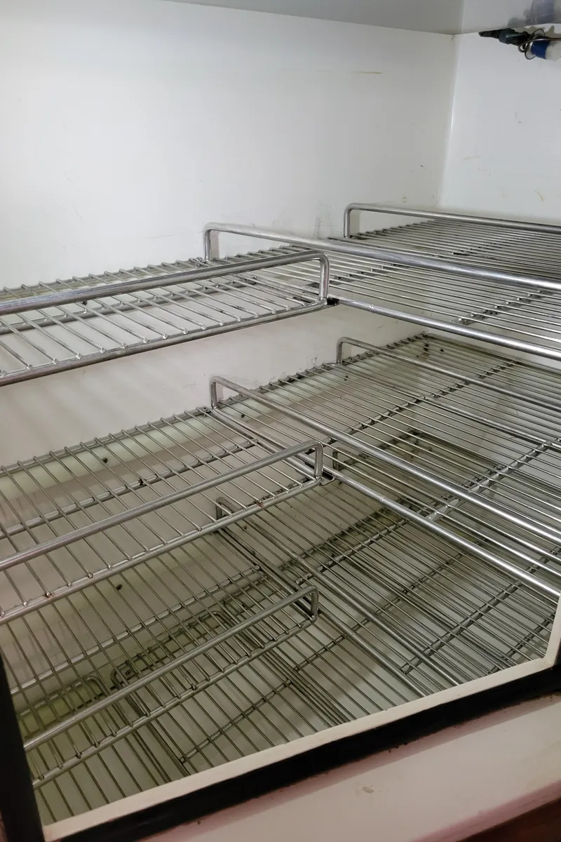 Slide: The Image of Empty metal shelves inside a refrigerator on a 1996 Little Harbor 51 Pilothouse yacht. - 29