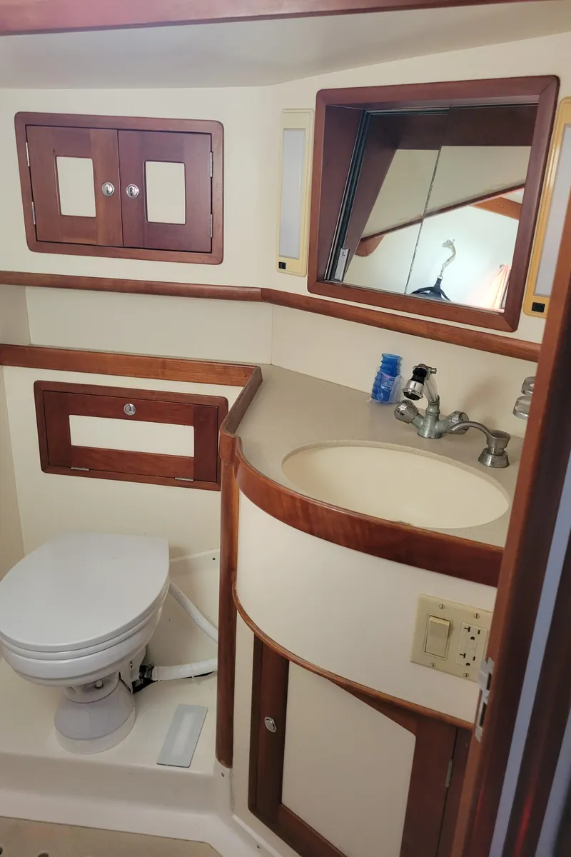 Slide: The Image of 1996 Little Harbor 51 Pilothouse bathroom with wood accents, sink, and toilet. - 42