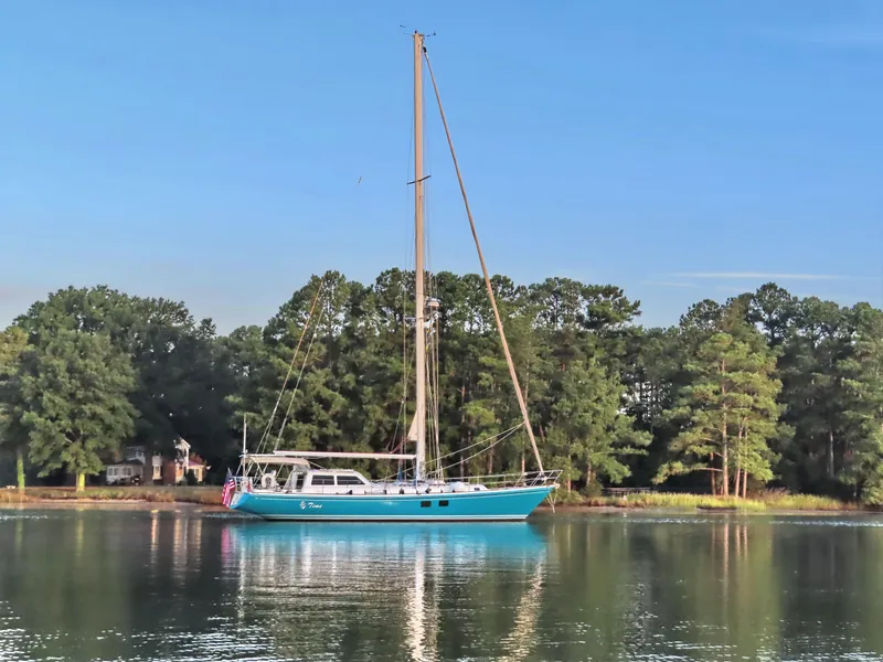 Slide: The Image of Sailboat "Little Harbor 51 Pilothouse" from 1996 on calm water, surrounded by trees. - 1