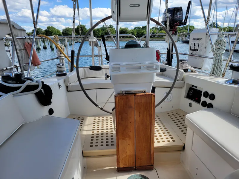 Slide: The Image of 1996 Little Harbor 51 Pilothouse yacht cockpit with steering wheel and seating, docked by the water. - 12