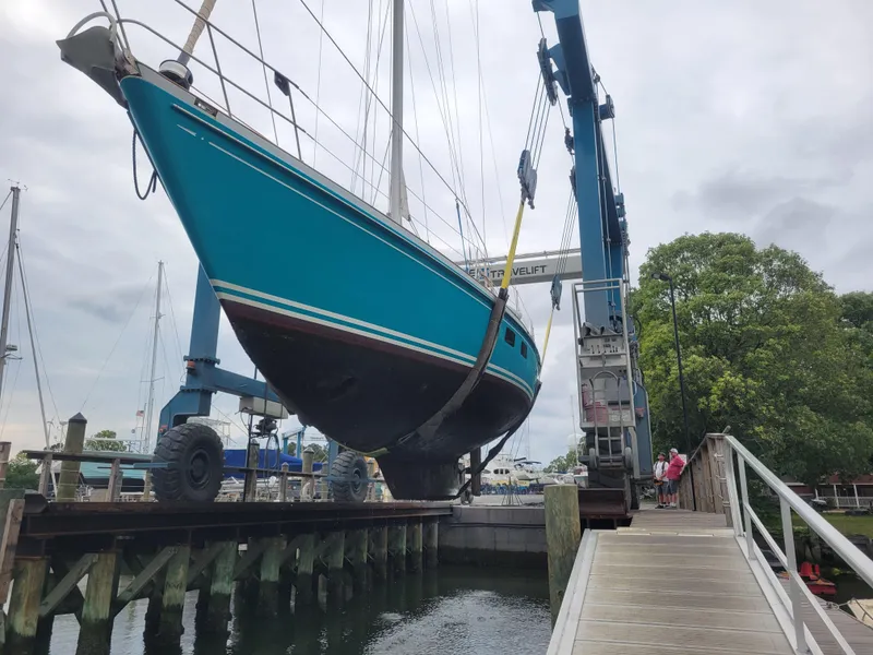 Slide: The Image of Little Harbor 51 Pilothouse sailboat being lifted by a travel lift at a marina. - 9