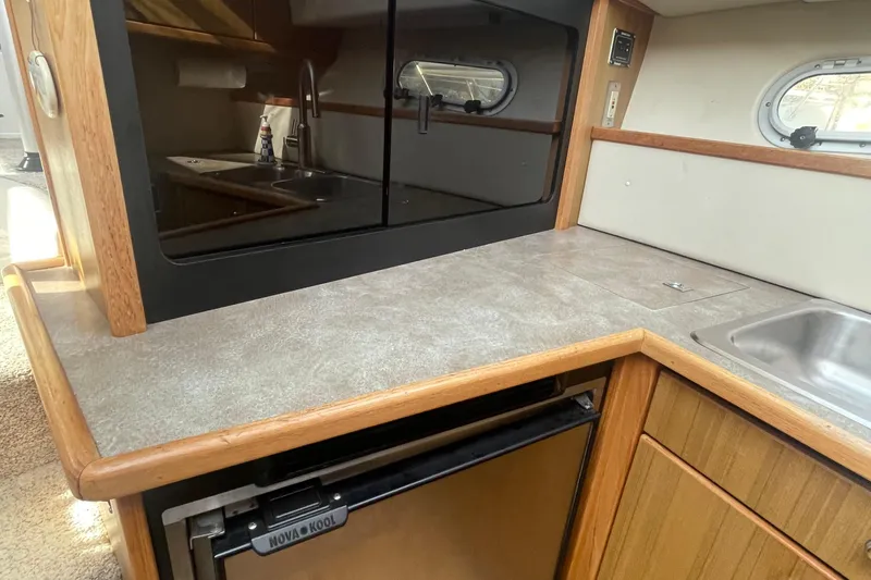Slide: The Image of 2001 Bayliner 3388 Command Bridge Motoryacht kitchen with sink, counter, and Nova Kool fridge. - 19