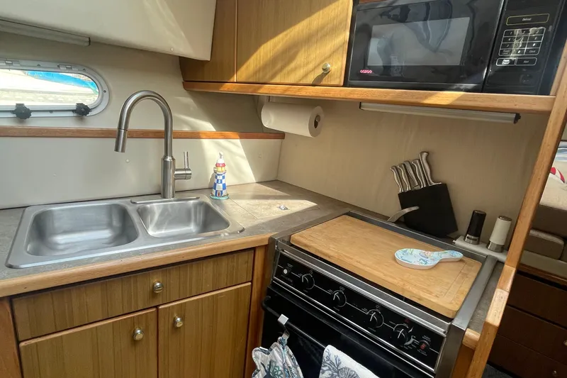 Slide: The Image of 2001 Bayliner 3388 Command Bridge Motoryacht kitchen with sink, stove, and microwave. - 20