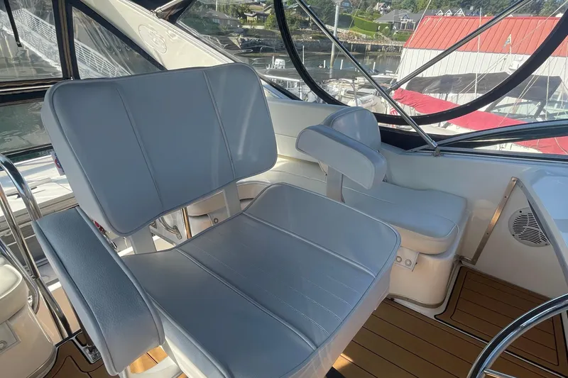 Slide: The Image of 2001 Bayliner 3388 Command Bridge Motoryacht interior with helm seats and marina view. - 25