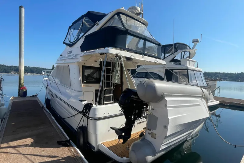 Slide: The Image of 2001 Bayliner 3388 Command Bridge Motoryacht docked at marina under clear blue sky. - 4