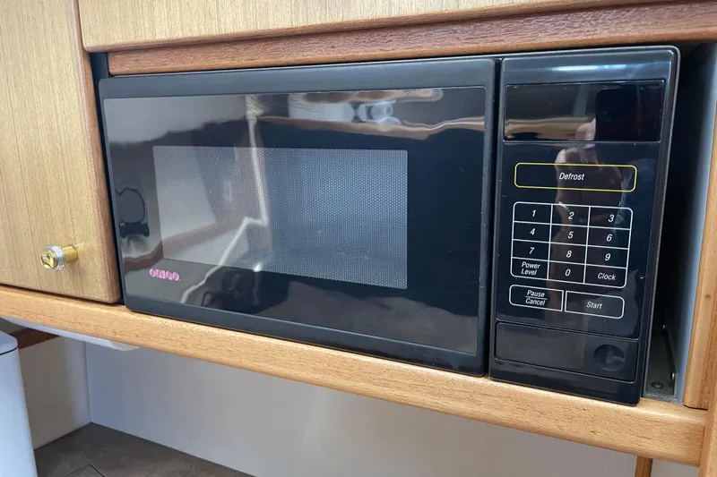 Slide: The Image of Microwave in 2001 Bayliner 3388 Command Bridge Motoryacht kitchen, featuring wood cabinetry. - 55