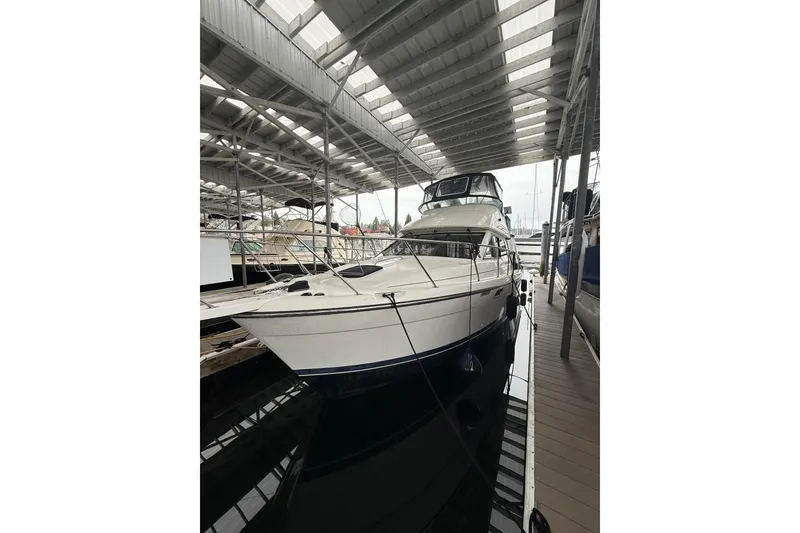 Slide: The Image of 2001 Bayliner 3388 Command Bridge Motoryacht docked under a covered marina. - 61