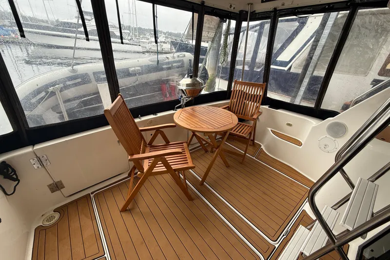 Slide: The Image of 2001 Bayliner 3388 Command Bridge Motoryacht interior with wooden chairs and table. - 63