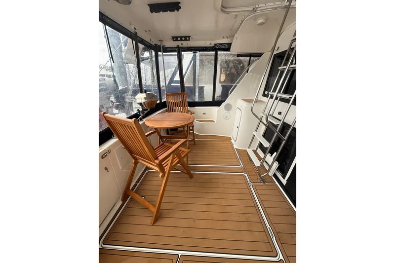 Slide: The Image of 2001 Bayliner 3388 Command Bridge Motoryacht interior with wooden chairs and table. - 64