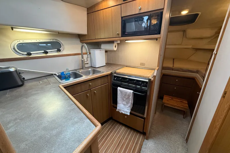 Slide: The Image of 2001 Bayliner 3388 Command Bridge Motoryacht kitchen with stove, sink, and microwave. - 77
