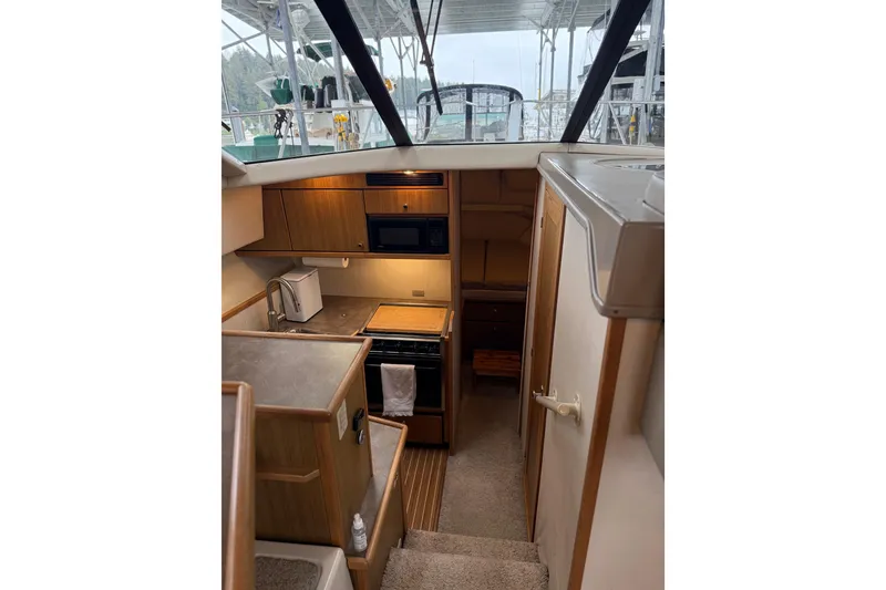 Slide: The Image of Interior of 2001 Bayliner 3388 Command Bridge Motoryacht, featuring kitchen and stairs. - 80