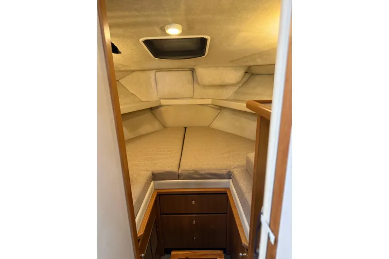 Slide: The Image of 2001 Bayliner 3388 Command Bridge Motoryacht cabin interior with cozy bed and wooden cabinetry. - 81