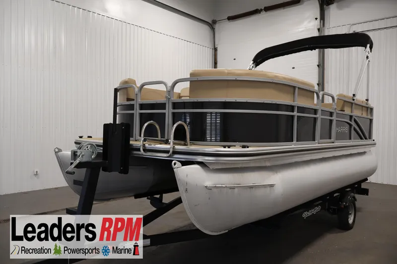 The Image of 2022 Harris Cruiser LX180 pontoon boat in indoor showroom, Leaders RPM branding visible. - 1