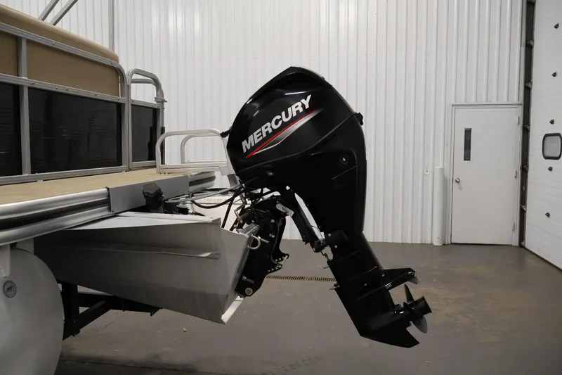 Slide: The Image of 2022 Harris Cruiser LX180 Cruise with Mercury outboard motor in a garage setting. - 26