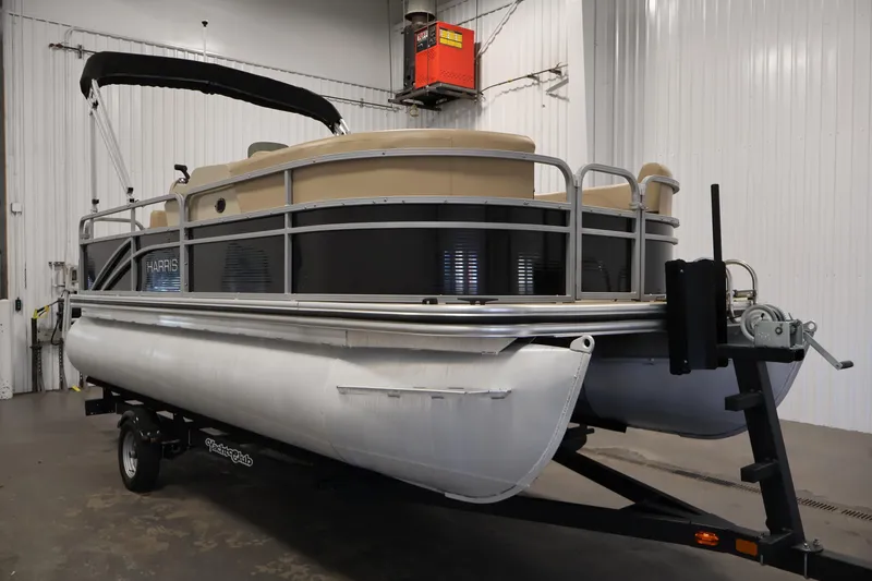 Slide: The Image of 2022 Harris Cruiser LX180 pontoon boat on trailer in indoor storage facility. - 3