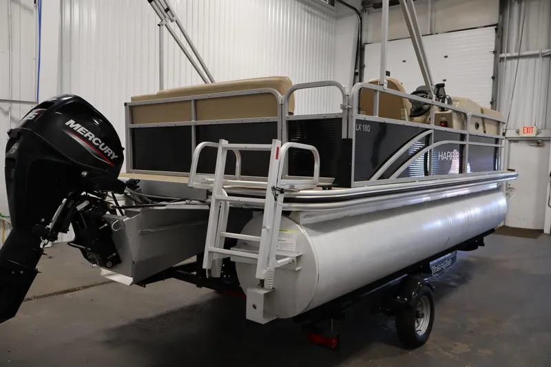 Slide: The Image of 2022 Harris Cruiser LX180 pontoon boat with Mercury engine in a garage. - 5