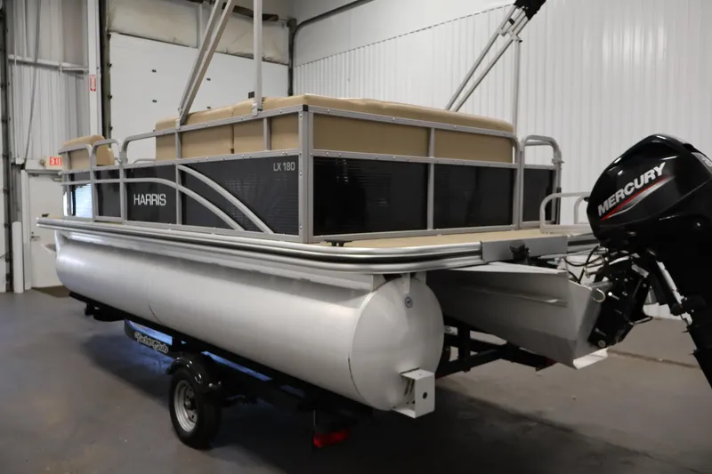 Slide: The Image of 2022 Harris Cruiser LX180 pontoon boat with Mercury outboard motor in a garage. - 7