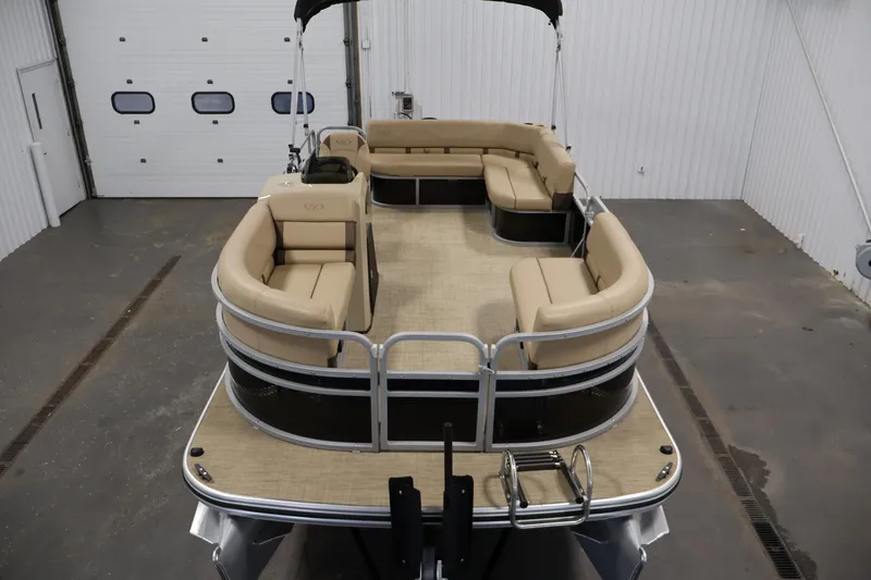 Slide: The Image of 2022 Harris Cruiser LX180 Cruise pontoon boat with beige seating in a garage. - 9