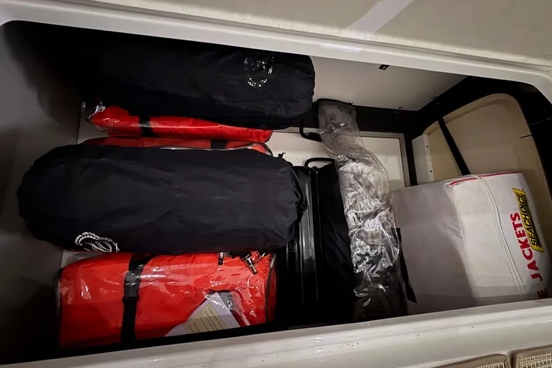 Slide: The Image of Storage compartment in a 2017 Cobalt R35 boat with life jackets and gear bags. - 29