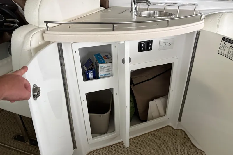 Slide: The Image of Interior of a 2017 Cobalt R35 boat showing open cabinet with storage and sink. - 40