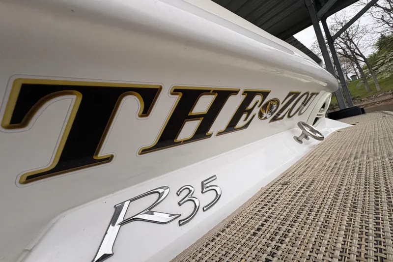 Slide: The Image of 2017 Cobalt R35 boat with "THE ZOU" lettering on the side, docked outdoors. - 48