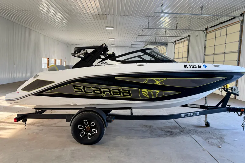 Slide: The Image of 2023 Scarab 195 ID boat in a garage, featuring sleek design and vibrant accents. - 12
