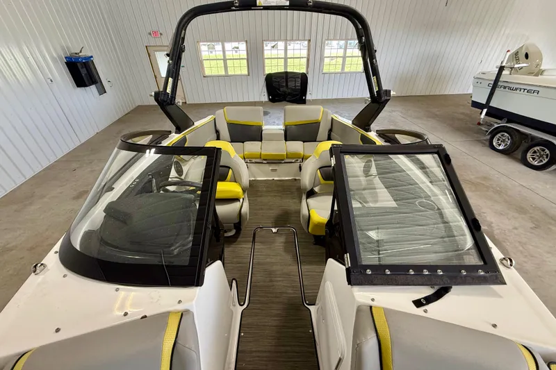 Slide: The Image of 2023 Scarab 195 ID boat interior with yellow accents in a spacious garage. - 14
