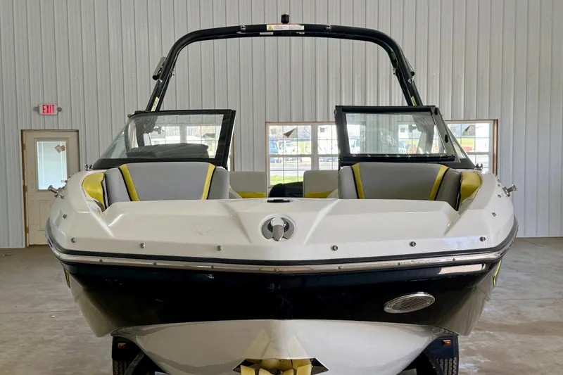 Slide: The Image of 2023 Scarab 195 ID boat on trailer in indoor storage facility. - 2