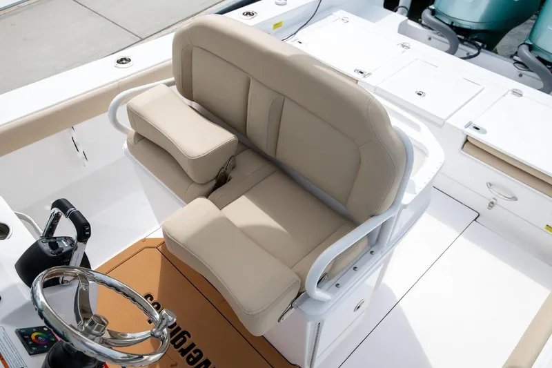 Slide: The Image of 2026 Everglades 273 Center Console boat with beige seating and steering wheel. - 10