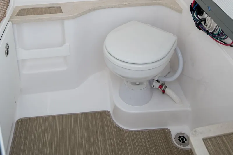 Slide: The Image of Interior of 2026 Everglades 273 Center Console boat featuring a compact marine toilet. - 13