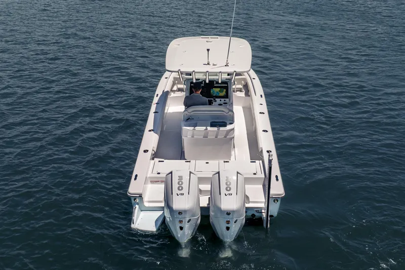 Slide: The Image of 2026 Everglades 273 Center Console boat on open water, rear view with dual engines. - 5
