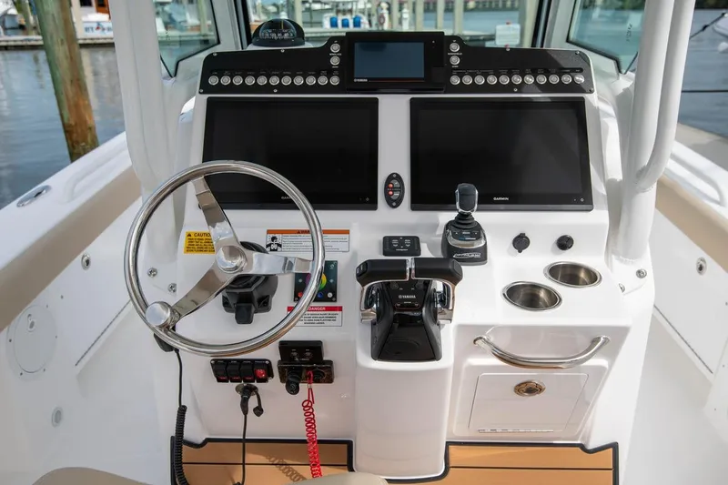 Slide: The Image of 2026 Everglades 273 Center Console boat dashboard with steering wheel and navigation screens. - 6