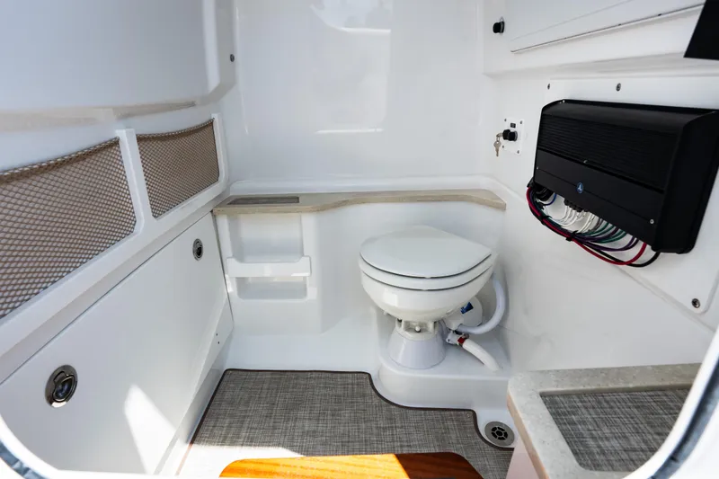 Slide: The Image of Interior of 2026 Everglades 273 Center Console boat featuring a compact marine toilet. - 22