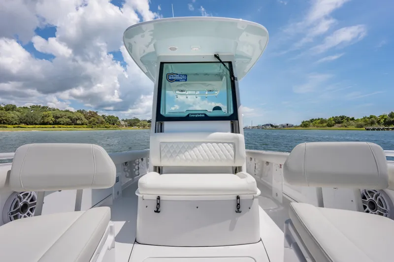 Slide: The Image of 2026 Everglades 273 Center Console boat interior with seating, on a scenic waterway. - 12