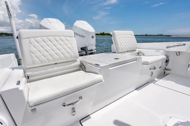 Slide: The Image of 2026 Everglades 273 Center Console boat interior with white seating and dual Mercury engines. - 10