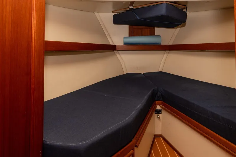 Slide: The Image of Interior cabin of a 2002 Nordic Tug 32 with blue cushions and wooden accents. - 10