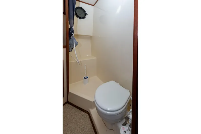 Slide: The Image of Bathroom interior of a 2002 Nordic Tug 32 boat, featuring a compact toilet. - 11