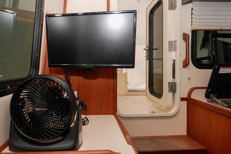Slide: The Image of Interior of 2002 Nordic Tug 32 with TV, fan, and cabin door. - 3