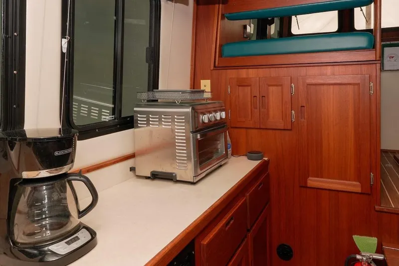 Slide: The Image of Interior of 2002 Nordic Tug 32 with kitchen appliances and wooden cabinetry. - 6