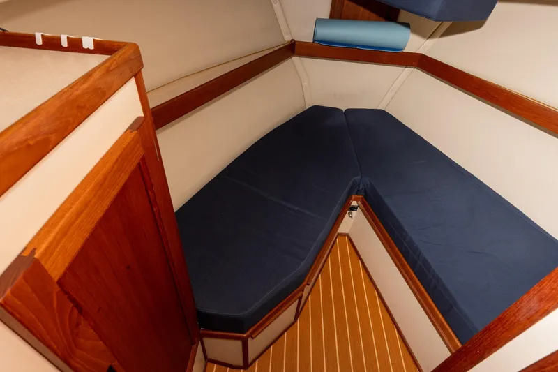 Slide: The Image of Cozy cabin interior of 2002 Nordic Tug 32 with blue cushions and wooden accents. - 9