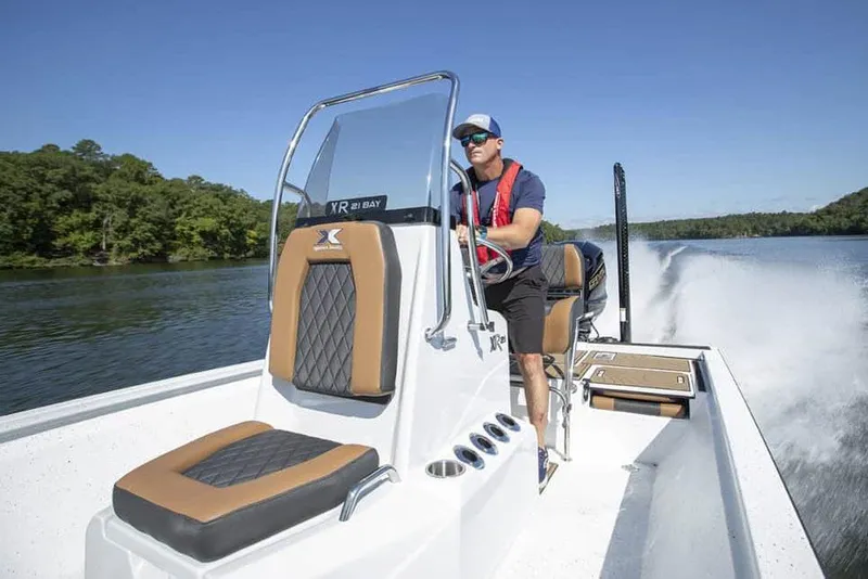 Slide: The Image of Manufacturer Provided Image: 2026 Xpress XR21B Bay boat cruising on a scenic lake with a driver. - 17