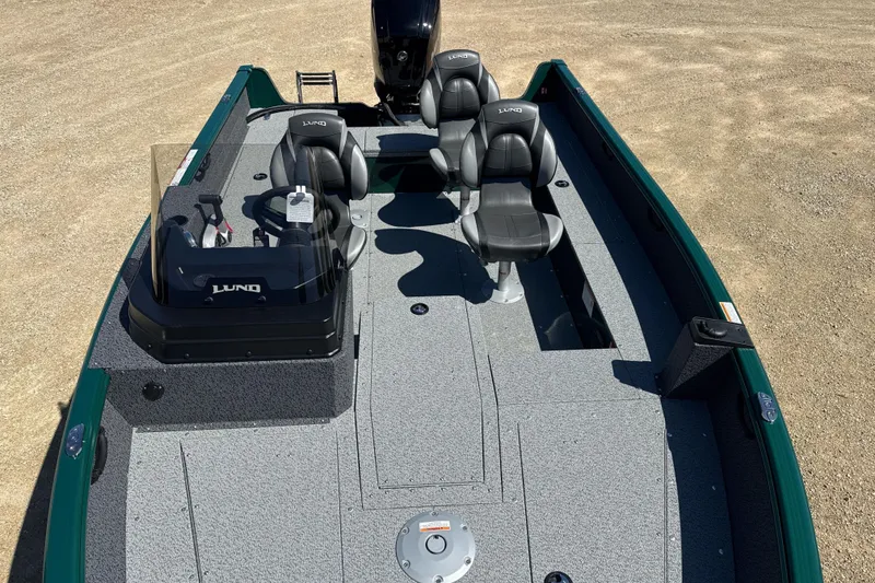 Slide: The Image of 2026 Lund 1700 Explorer SS boat interior with seating and console, parked on sandy ground. - 8