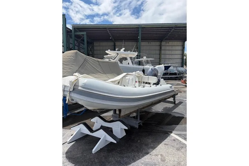 The Image of 2010 Nautica RIB 14 inflatable boat stored in a marina, partially covered. - 1
